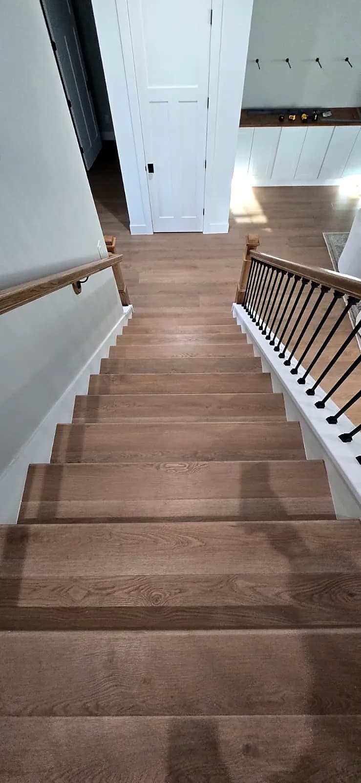 Stair treads and upstairs hallway finished in oak-look plank flooring